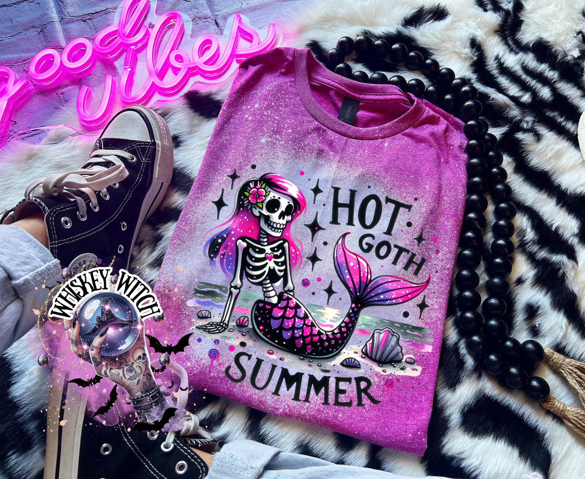 A Berry colored t-shirt with a bleach-splattered design featuring a pink and purple skeleton mermaid with the text "Hot Goth Summer".