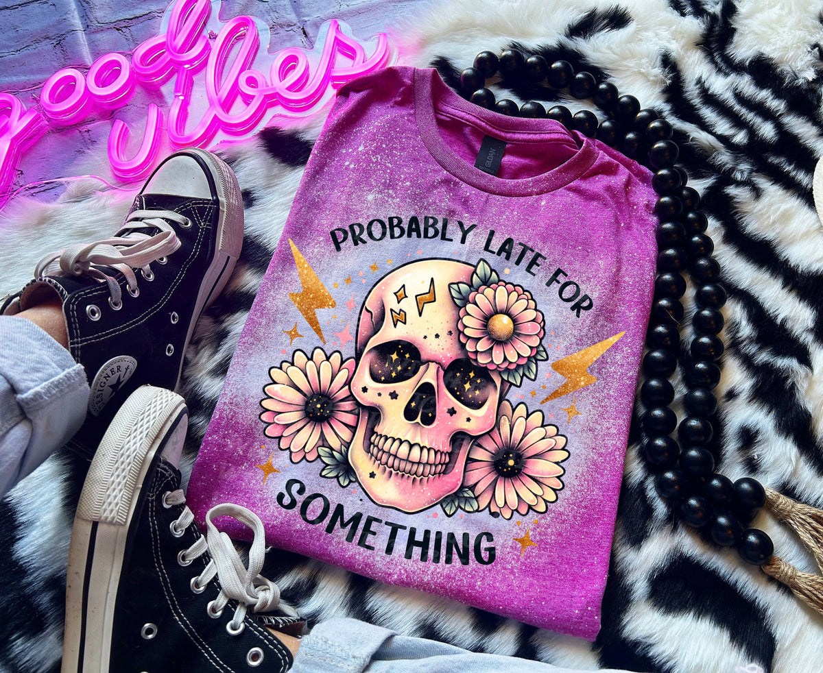 A Berry pink t-shirt with a bleached effect featuring a skull with flowers and the text "Probably Late For Something" in gold glitter.