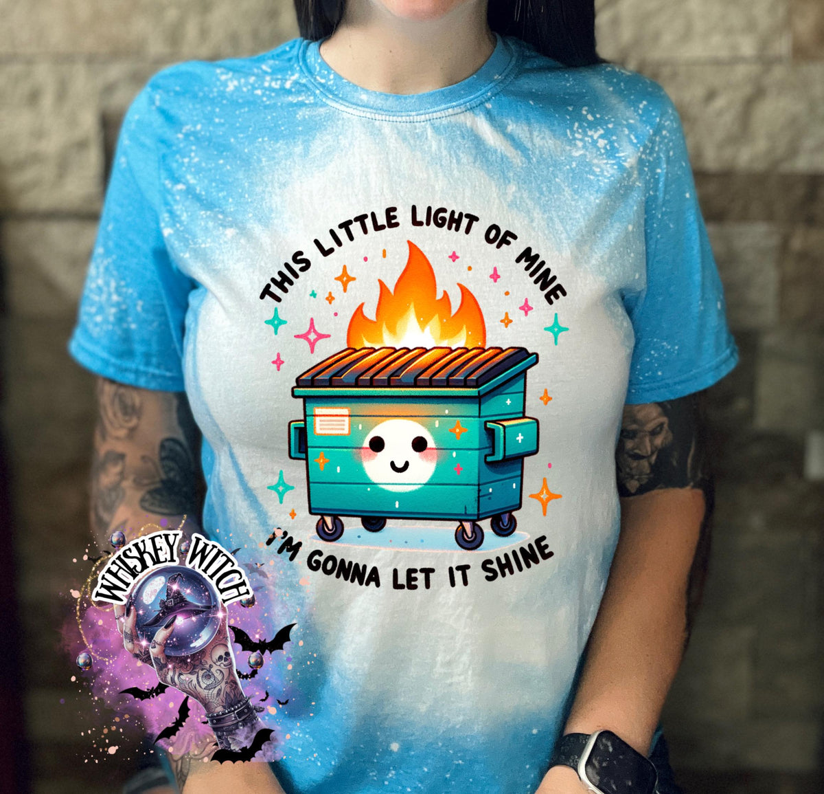 Sapphire Blue  t-shirt with a bleach-splattered design featuring a cartoon dumpster on fire with the text "This little light of mine I'm gonna let it shine".