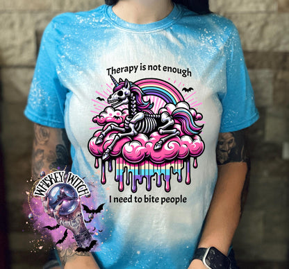 A sapphire blue  and bleached design T shirt with a skeleton unicorn and a rainbow with a dripping colored cloud with the words “Therapy is not enough, I need to bite people.”