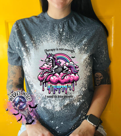 A gre and bleached design T shirt with a skeleton unicorn and a rainbow with a dripping colored cloud with the words “Therapy is not enough, I need to bite people.”