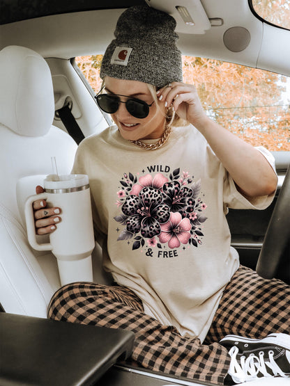 Light pink unisex sweatshirt with ‘Wild & Free’ leopard floral hibiscus graphic in black and pink