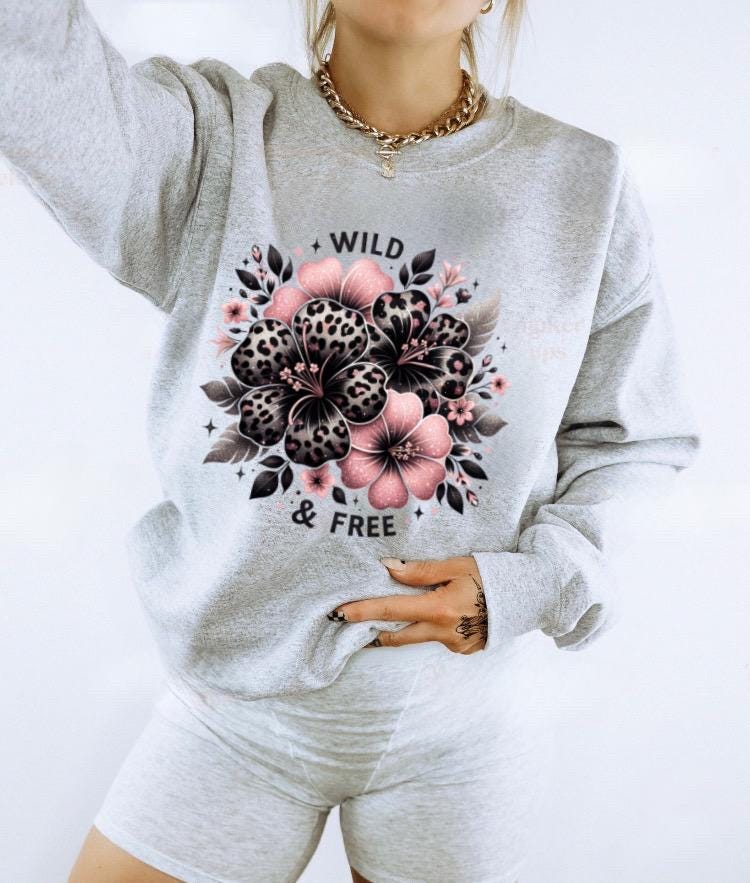 Light pink unisex sweatshirt with ‘Wild & Free’ leopard floral hibiscus graphic in black and pink