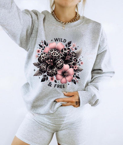 Light pink unisex sweatshirt with ‘Wild & Free’ leopard floral hibiscus graphic in black and pink