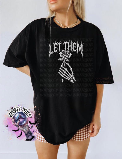 Black oversized t-shirt with the text "LET THEM" in a gothic font, and a skeleton hand holding a rose.