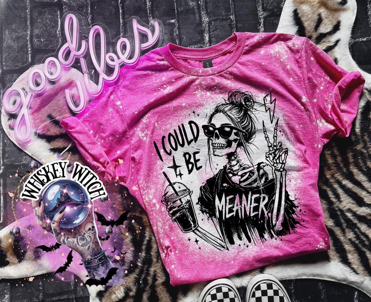 Pink t-shirt with a bleached effect, featuring a skeleton graphic wearing sunglasses and holding a drink. The text "I COULD BE MEANER" is printed on the shirt. The image also includes the text "Good Vibes" in neon pink.