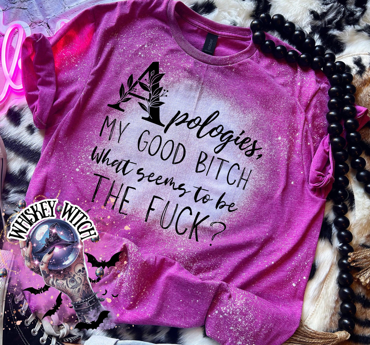 A Berry pink t-shirt with a bleached design and the text "Apologies, MY GOOD BITCH What seems to be THE FUCK?". The shirt has a round neck and short sleeves.