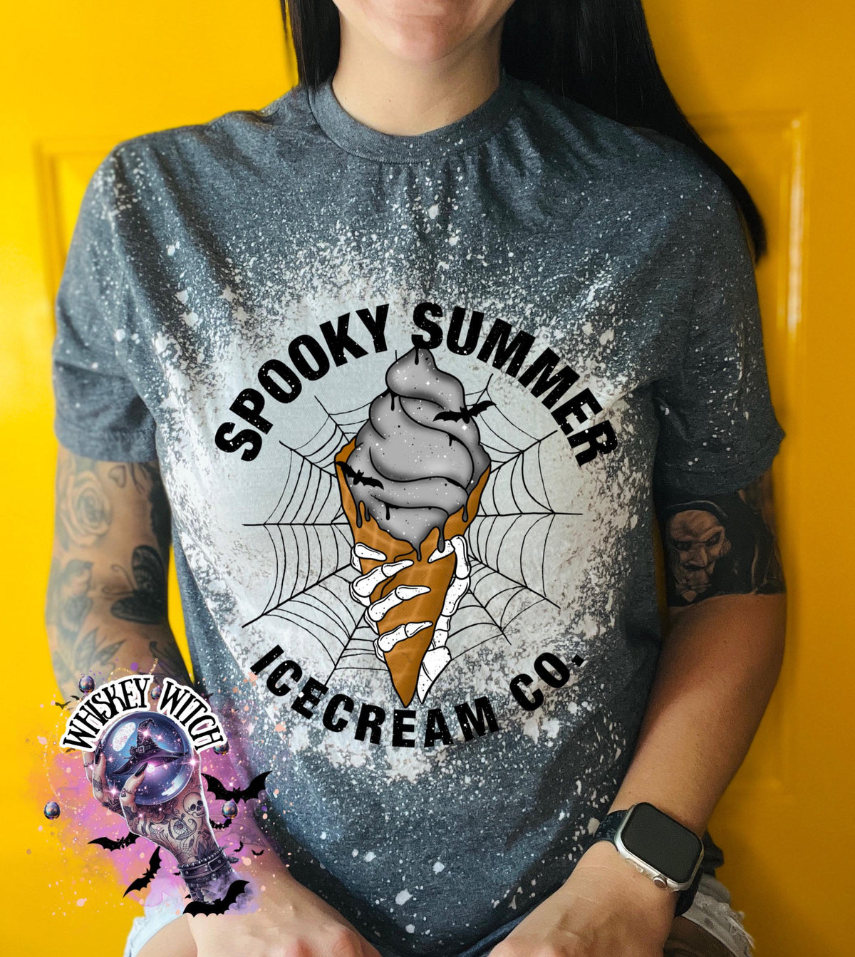 A gray t-shirt with a distressed, bleached design. The shirt features a circular graphic with the words "Spooky Summer Icecream Co." surrounding a spooky ice cream cone design with a spider web and bats.