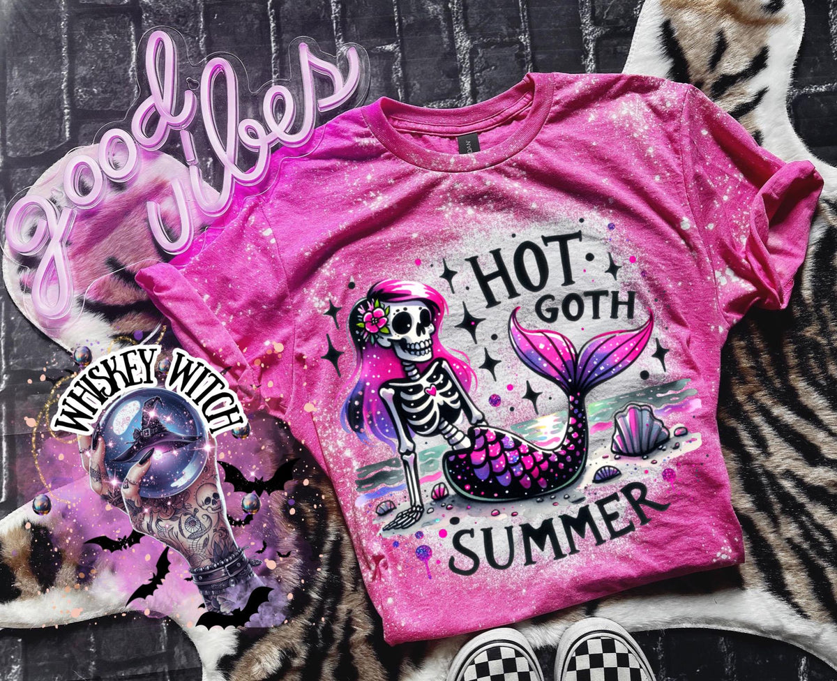 A pink t-shirt with a bleach-splattered design featuring a pink and purple skeleton mermaid with the text "Hot Goth Summer". Cute summer shirt, goth summer shirt, cute summer shirt, bleached tee.