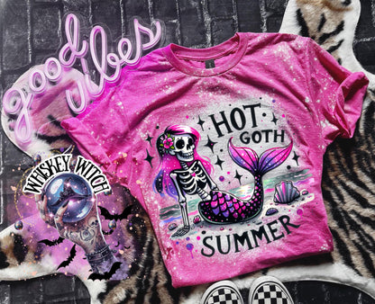 A pink t-shirt with a bleach-splattered design featuring a pink and purple skeleton mermaid with the text "Hot Goth Summer". Cute summer shirt, goth summer shirt, cute summer shirt, bleached tee.