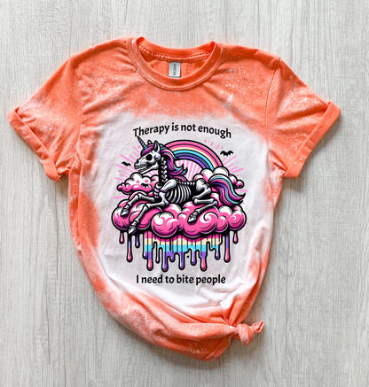A Orange  and bleached design T shirt with a skeleton unicorn and a rainbow with a dripping colored cloud with the words “Therapy is not enough, I need to bite people.”