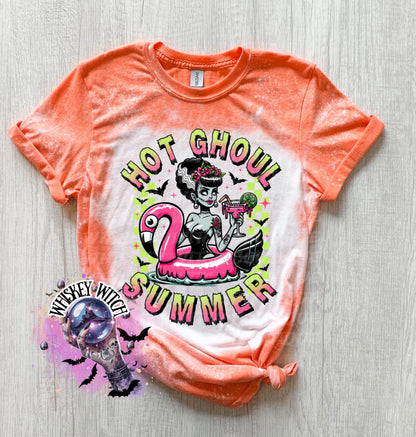 A Orange and bleach splattered effect  t-shirt with a graphic of a zombie woman in a flamingo pool float, holding a cocktail. The text "Hot Ghoul Summer" is printed on the shirt.