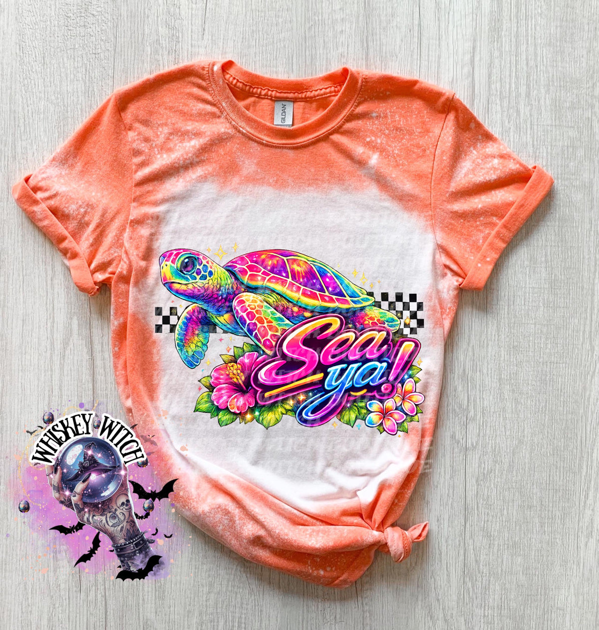 A orange t-shirt with bleach white effect a colorful graphic of a sea turtle, flowers, and the words "Sea Ya!". The shirt has a bleached, distressed look. The design features vibrant colors and a playful font.