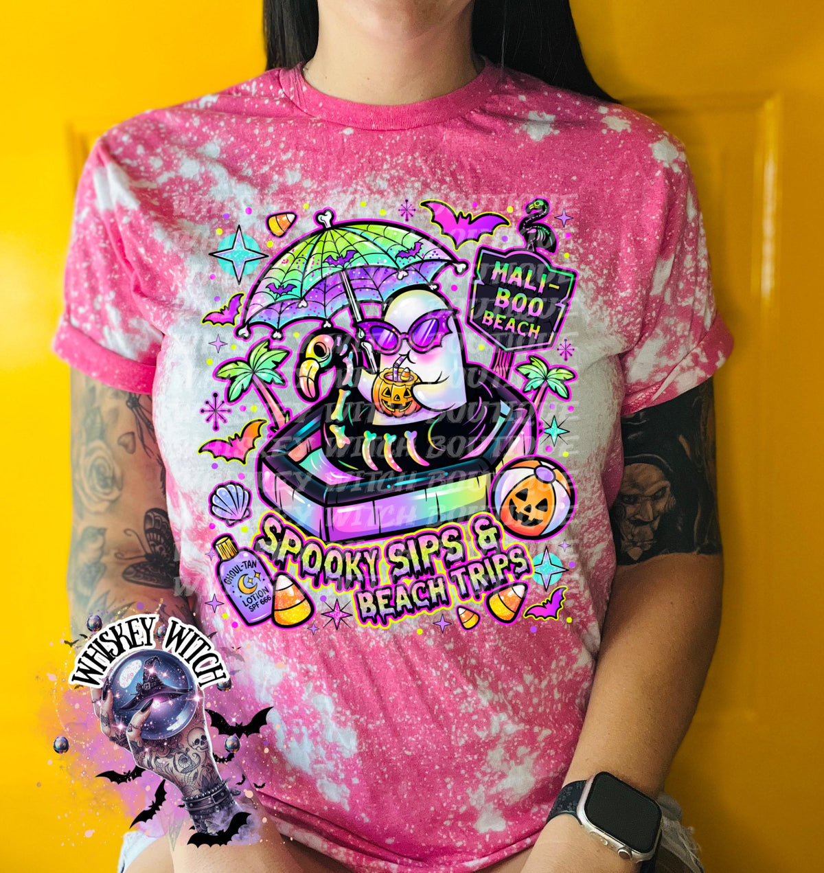 Close-up of spooky beach shirt design with ghost in float, tropical palm trees, bats, candy corn, and neon summer colors.