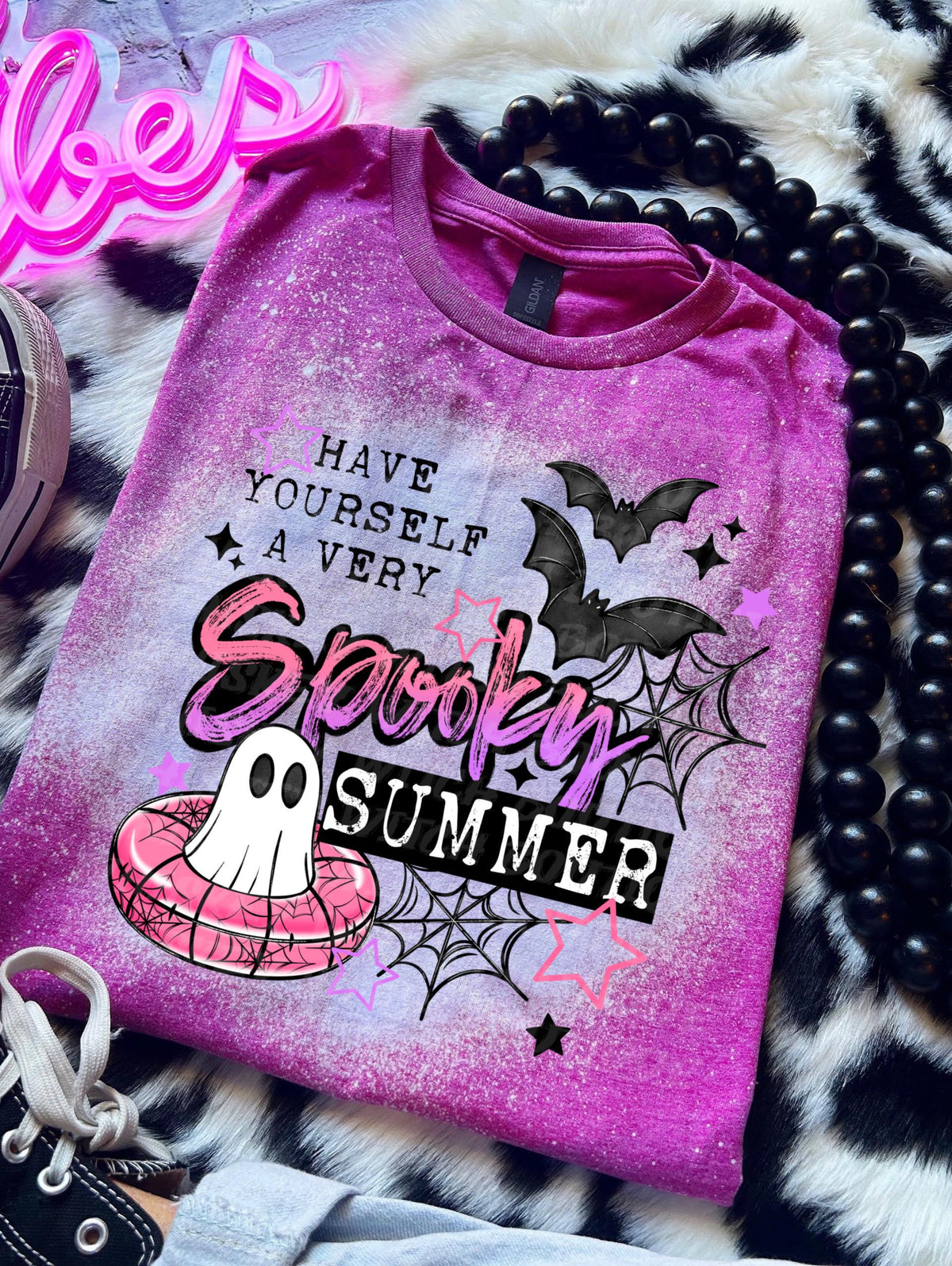 Cute ghost pool float graphic shirt with pink, black, and white summerween design details. Pink/Berry Bleached design