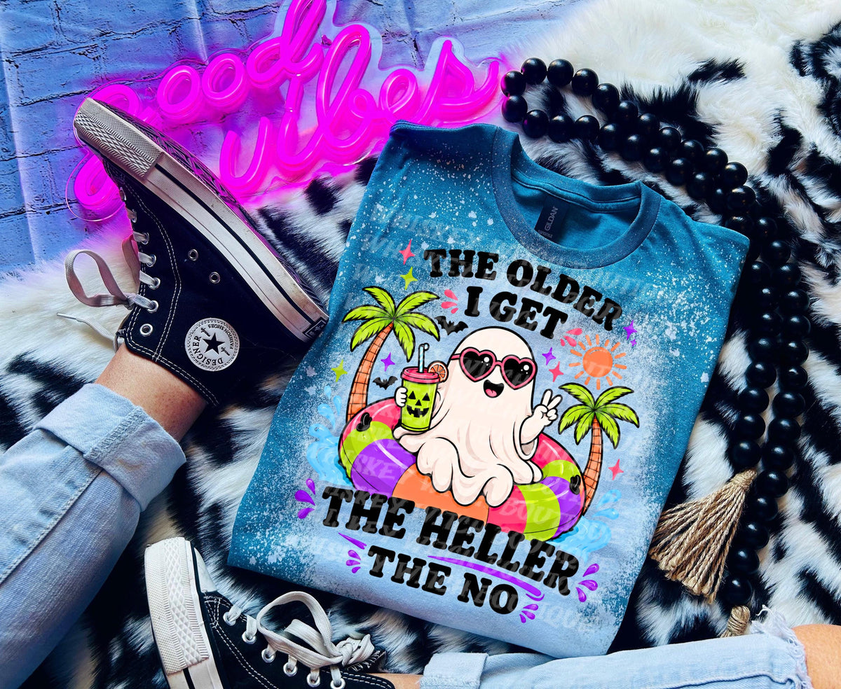 A blue t-shirt with a graphic of a ghost wearing sunglasses and a drink, with the text "The Older I Get The Heller The No". The shirt is paired with black Converse sneakers.